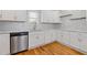 Bright kitchen featuring white cabinets, stainless steel dishwasher, subway tile backsplash, and hardwood floors at 1598 Jonesboro Se Rd, Atlanta, GA 30315