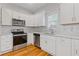 Modern kitchen featuring white cabinets, stainless steel appliances, and an elegant marble tile backsplash at 1598 Jonesboro Se Rd, Atlanta, GA 30315