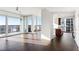 Open floor plan with hardwood floors, large windows leading to balcony, and view of the kitchen at 3325 Piedmont Ne Rd # 1502, Atlanta, GA 30326