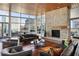 Bright living room with stone fireplace, hardwood floors, and floor to ceiling windows at 3325 Piedmont Ne Rd # 1502, Atlanta, GA 30326