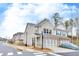 Well-manicured townhome exterior with a two-car garage and a view of the community street at 539 Walton Dr, Woodstock, GA 30188