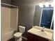 Bathroom with white tub, toilet, and a wood vanity cabinet, creating a simple and functional space at 5768 Windgate Ln, Lithonia, GA 30058