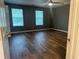 Bedroom showcasing wood-look floors, a ceiling fan, and natural light from two windows at 5768 Windgate Ln, Lithonia, GA 30058