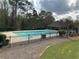 Community swimming pool area featuring clean pool, shaded seating, and manicured landscape at 2304 Northglenn Ct, Conyers, GA 30013
