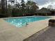 Sparkling community swimming pool with a covered pavilion surrounded by lush trees at 2304 Northglenn Ct, Conyers, GA 30013