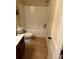 Cozy bathroom featuring a tub with white tile and a decorative vanity with dark cabinets at 2304 Northglenn Ct, Conyers, GA 30013