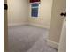 A carpeted bedroom with a window, neutral walls, and white trim throughout at 2304 Northglenn Ct, Conyers, GA 30013