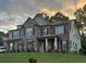 Two-story brick and stone home with a gable roof, covered front porch, and lush green lawn at 2304 Northglenn Ct, Conyers, GA 30013