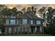 Well-maintained two-story brick and stone home with symmetrical windows and a covered front porch at 2304 Northglenn Ct, Conyers, GA 30013