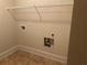 The laundry room has tile floors, utility hookups, and a shelf for storage at 2304 Northglenn Ct, Conyers, GA 30013