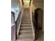 A staircase with carpeted steps and a decorative wooden banister leads to the upper level at 2304 Northglenn Ct, Conyers, GA 30013