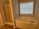 Bathroom featuring a tub with glass doors and a large window at 3305 Wolverton Sw Ct, Conyers, GA 30094