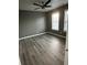 Brightly lit bedroom featuring two windows, ceiling fan and gray wood floors at 3305 Wolverton Sw Ct, Conyers, GA 30094