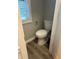 Cozy powder room with a toilet in a neutral color palette and wood-look floors at 3305 Wolverton Sw Ct, Conyers, GA 30094