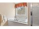 Bright bathroom with white tub next to a window and glass shower at 1657 Stilesboro Ridge Dr, Kennesaw, GA 30152