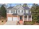 Charming two-story home with brick and gray siding, a welcoming front porch, and a well-manicured lawn, perfect for curb appeal at 1657 Stilesboro Ridge Dr, Kennesaw, GA 30152