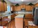 Well-lit kitchen features wood cabinets, an island with granite countertops, and stainless steel appliances at 1657 Stilesboro Ridge Dr, Kennesaw, GA 30152