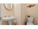 Neutral powder room with a pedestal sink, toilet, and decorative wall art at 1657 Stilesboro Ridge Dr, Kennesaw, GA 30152