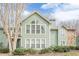 Charming two-story home with green siding, large windows, and well-maintained landscaping at 3205 Canyon Point Cir, Roswell, GA 30076