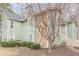 Exterior view of a condo featuring stone accents, green siding, and a well-kept lawn at 3205 Canyon Point Cir, Roswell, GA 30076