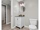 Half bathroom with white vanity, round mirror, updated light fixture and plank flooring at 2275 Perch Sw Way, Marietta, GA 30008