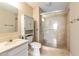 Well-lit bathroom featuring a toilet, vanity, and glass-enclosed shower with tiled walls at 300 Johnson Ferry Ne Rd # B401, Atlanta, GA 30328
