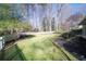 Grassy backyard area with mature trees and white picket fence at 1903 Olde Village Run, Dunwoody, GA 30338