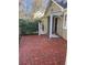 Brick patio area alongside house and detached garage with black doors at 1903 Olde Village Run, Dunwoody, GA 30338