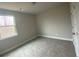 An empty bedroom with neutral walls, carpeted floors, and a bright window at 5021 Falcon Pt, Douglasville, GA 30135