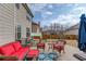 Backyard patio with red cushioned sofa and a blue patterned rug at 1660 Silver Crest Way, Hoschton, GA 30548