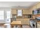 Sunlit kitchen boasts modern appliances, granite countertops, and a view to the backyard at 4265 Elmhurst Ln, Cumming, GA 30028