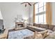 Bright living room featuring a stone fireplace, tall windows, and a comfortable sectional sofa at 4265 Elmhurst Ln, Cumming, GA 30028