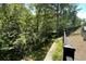 Backyard view surrounded by lush greenery and a black metal fence for added privacy at 353 Vista Ln, Woodstock, GA 30189