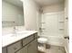 Well-lit bathroom featuring a single sink vanity, tile floors, and a shower-tub combination with white surround at 353 Vista Ln, Woodstock, GA 30189