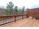 Wooden deck with railings offers an outdoor space for relaxation with a wooded view at 353 Vista Ln, Woodstock, GA 30189