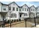 Charming exterior view of townhome with iron fence, trimmed bushes and neutral paint at 353 Vista Ln, Woodstock, GA 30189