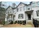 Exterior view of a two-story townhome featuring a gray front door and manicured landscaping at 353 Vista Ln, Woodstock, GA 30189