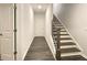 Entry hallway with wood-look flooring, staircase with wooden railing, and a glimpse into connected rooms at 353 Vista Ln, Woodstock, GA 30189