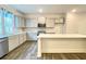 Open kitchen with white cabinets, large island, stainless appliances, and hardwood flooring at 353 Vista Ln, Woodstock, GA 30189