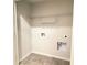 Practical laundry area with tile floor, utility connections, and shelving ready for washer, dryer, and storage at 353 Vista Ln, Woodstock, GA 30189