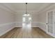 Bright dining room with hardwood floors, tray ceiling, chandelier, and glass-paneled door at 2541 Berwick Walk, Snellville, GA 30078