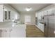 Modern kitchen featuring stainless steel appliances, white cabinets, quartz countertops, and hardwood floors at 2541 Berwick Walk, Snellville, GA 30078