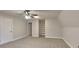 A cozy carpeted bedroom with a ceiling fan and shelving at 250 Southmoor Cir, Stockbridge, GA 30281