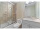 Bathroom featuring a shower over bath with glass doors, white vanity, and neutral decor at 750 Park Ne Ave # 21E, Atlanta, GA 30326