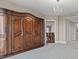 Bedroom with a large wood wardrobe, gray carpet, chandelier, and view into the dining room at 750 Park Ne Ave # 21E, Atlanta, GA 30326