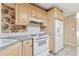 Functional kitchen with white appliances, wood cabinets, and a tiled floor at 2057 Sugar Pike Rd, Woodstock, GA 30188
