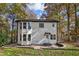 A renovated home with black trim on windows and a rear brick patio surrounded by green grass and trees at 2190 Lakeway Dr, Dacula, GA 30019