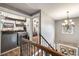 Upper hallway featuring laundry area, chandelier, and an open staircase with wood and iron railings at 1081 Walnut Creek Dr, Woodstock, GA 30188