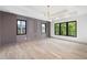 Bright bedroom with hardwood floors, modern chandelier, and three black-trim windows at 401 Lynne Cir, Alpharetta, GA 30009