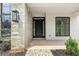 Close-up of front door showcasing stone accents, modern black door and stylish lantern lighting at 401 Lynne Cir, Alpharetta, GA 30009